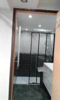 a bathroom with a shower and a sink and a mirror at appartement au rez de jardin in Morangis