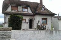 a house with a stone fence in front of it at appartement au rez de jardin in Morangis