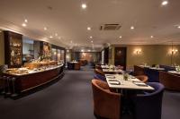 a restaurant with long tables and blue chairs at Mabu Curitiba Business in Curitiba
