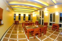 a restaurant with wooden tables and chairs and yellow walls at Hotel Glory Garden in Pokhara
