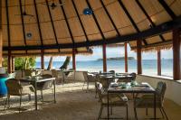 un restaurante en la playa con mesas y sillas en Dhawa Ihuru, part of Banyan Group, en Male