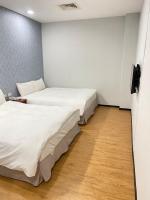 two beds in a small room with wooden floors at The Prince Hotel in Tainan