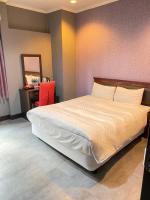a bedroom with a bed and a desk and a mirror at The Prince Hotel in Tainan
