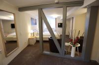 a room with a mirror and a bedroom with a bed at Pension Alte Scheune in Melsungen