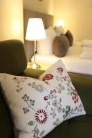 a pillow with a flower pattern on it next to a bed at Pension Alte Scheune in Melsungen