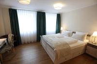 a bedroom with a large bed with green curtains at Pension Alte Scheune in Melsungen