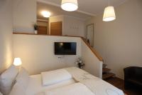 a living room with a white couch and a tv at Pension Alte Scheune in Melsungen