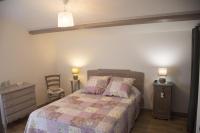 a bedroom with a bed and two tables and a chair at Gite de la haute roche in Charroux