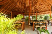 スリタヌにあるSeaflower Bungalowsの木製のテーブルと椅子と植物のあるレストラン