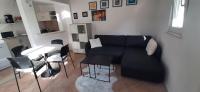 - un salon avec un canapé noir et une table dans l&#39;établissement Apartment Nika on the beach Mlini, à Mlini