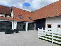 a white building with a red roof and a white fence at A la ferme in Kurtzenhouse