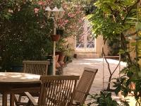 a patio with a table and chairs and a street light at Villa, avec piscine chauffée in Servian