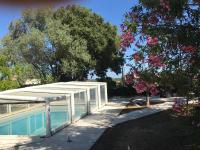 a swimming pool with a white canopy next to a tree at Villa, avec piscine chauffée in Servian
