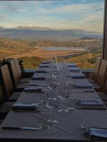 a long table with wine glasses and a mountain in the background at Case al Borgo - Albergo diffuso in Agira