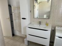a white bathroom with a sink and a mirror at Les oliviers in Juvignac