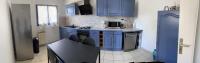 a kitchen with blue cabinets and a counter top at Les oliviers in Juvignac