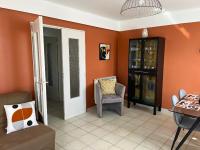 a living room with orange walls and a chair at Les oliviers in Juvignac