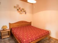 a small bedroom with a bed with a red bedspread at Appartement Aussois, 2 pièces, 4 personnes - FR-1-508-68 in Aussois