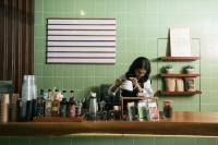 Una mujer parada detrás de un mostrador en una cocina. en LAYANA FARMSTAY, en Banyuwangi