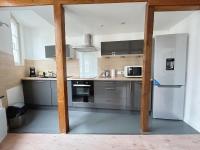 a kitchen with stainless steel appliances and wooden beams at L&#39;appartement du Centre in Chalons en Champagne