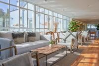 a living room with a couch and tables and windows at PortoBay Serra Golf in Santo António da Serra