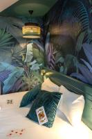 a bedroom with a bed with a mural of plants at Hôtel Grand Confort Le Moulin Rouge in Terrasson-Lavilledieu