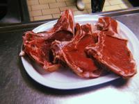 Un plato blanco con dos trozos de tocino encima. en Rifugio del Cavaliere, en Ateleta