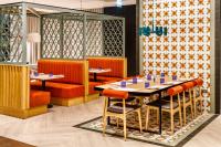 a dining room with tables and orange chairs at Holiday Inn Manchester Airport T2 by IHG in Hale