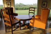 Una mesa y sillas en una habitación con ventana. en Hotel Sarai Bharatgarh, en Chandīgarh