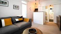 a living room with a couch and a kitchen at Studio Casa Aelys - Quartier des Arènes - Béziers in Béziers