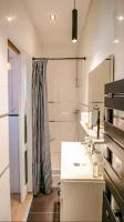 a white kitchen with a sink and a shower at Studio Casa Aelys - Quartier des Arènes - Béziers in Béziers