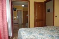 a bedroom with a bed and a door to a hallway at Hotel Villa Ruscello in Baveno