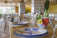 a table with two plates and wine glasses on it at Alfahar Hotel in Carmen de Viboral