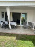 a patio with a table and chairs on a house at Maison Agréable Familiale in Saint-François