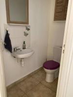 a bathroom with a sink and a toilet with a purple seat at Maison Agréable Familiale in Saint-François