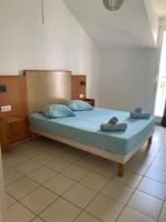 a bedroom with a bed with two towels on it at Maison Agréable Familiale in Saint-François