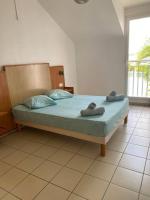 a bedroom with a bed with two towels on it at Maison Agréable Familiale in Saint-François