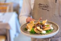 uma pessoa está segurando um prato de comida em Albergo Croce d'Aune em Pedavena