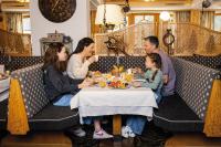 a family sitting at a table in a restaurant at Familotel Kindl in Neustift im Stubaital