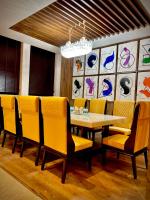 een eetkamer met een tafel en gele stoelen bij The Mars Resorts in Meerut