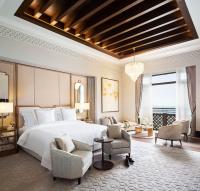 a bedroom with a large bed and two chairs at Jumeirah Mina Al Salam Dubai in Dubai