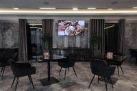 a dining room with a table and chairs and a tv at President Hotel&Restaurant&SPA in Trostyanets