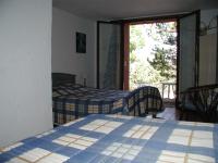 a bedroom with two beds and a sliding glass door at Chambres d’hôte l&#39;Amandière à Cucugnan in Cucugnan