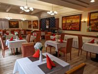 un restaurante con mesas y sillas blancas y servilletas rojas en Hotel Barbakan, en Trnava
