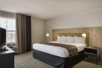 Una habitación de hotel con una cama grande y un televisor. en GreenTree Inn &amp; Suites Phoenix Sky Harbor, en Phoenix