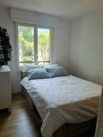 a bed in a room with a window at Appartement de charme proche de la mer in Hyères