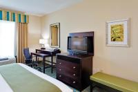 ein Hotelzimmer mit einem Bett, einem Schreibtisch und einem Fernseher in der Unterkunft Holiday Inn Express Hotel &amp; Suites Gulf Shores by IHG in Gulf Shores