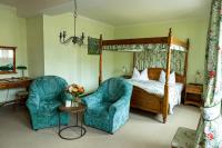 a bedroom with a canopy bed and two chairs at Hotel Anker in Saalfeld