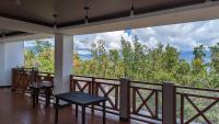 a room with a balcony with a view of trees at Bakawan Hideaway Resort and Restaurant in Tomas Oppus