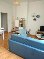 a living room with a blue couch and a chair at Appartement calme proche de la Loire in Saumur